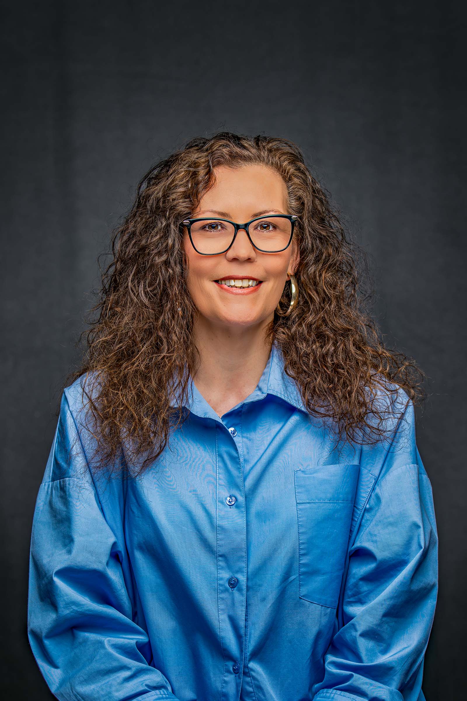 Approachable corporate portrait of a woman in a blue shirt