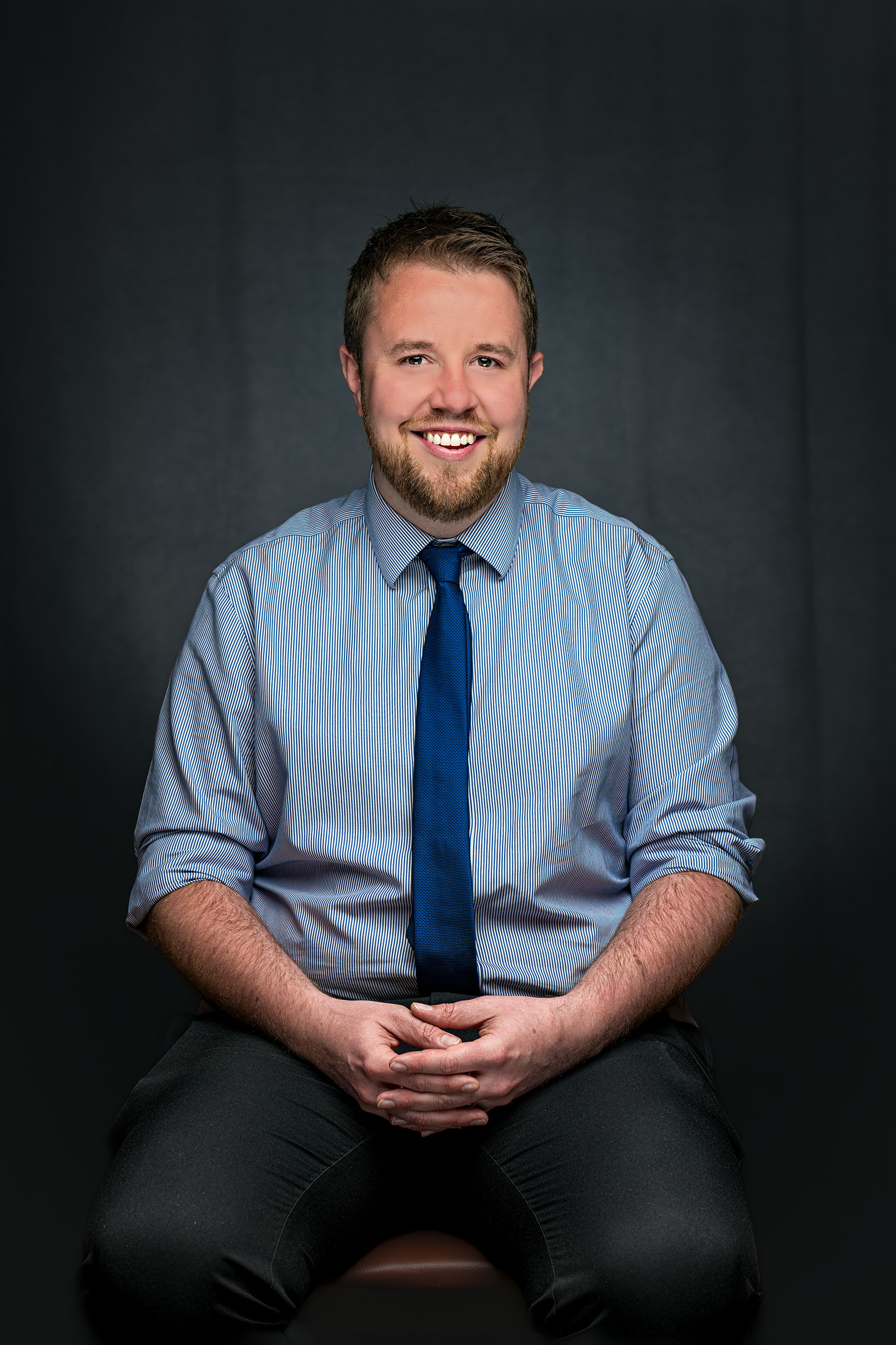 Smiling corporate portrait of a man wearing a shirt and tie