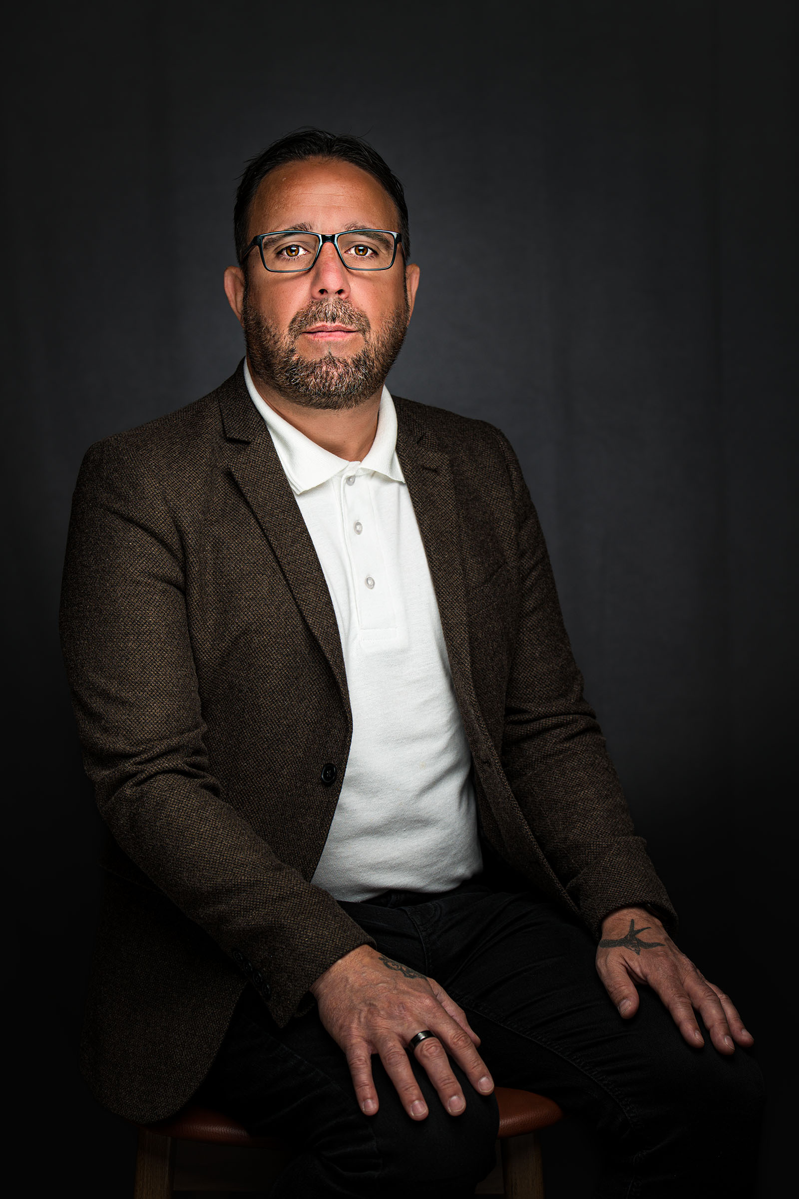 Formal seated business portrait of a man in a jacket