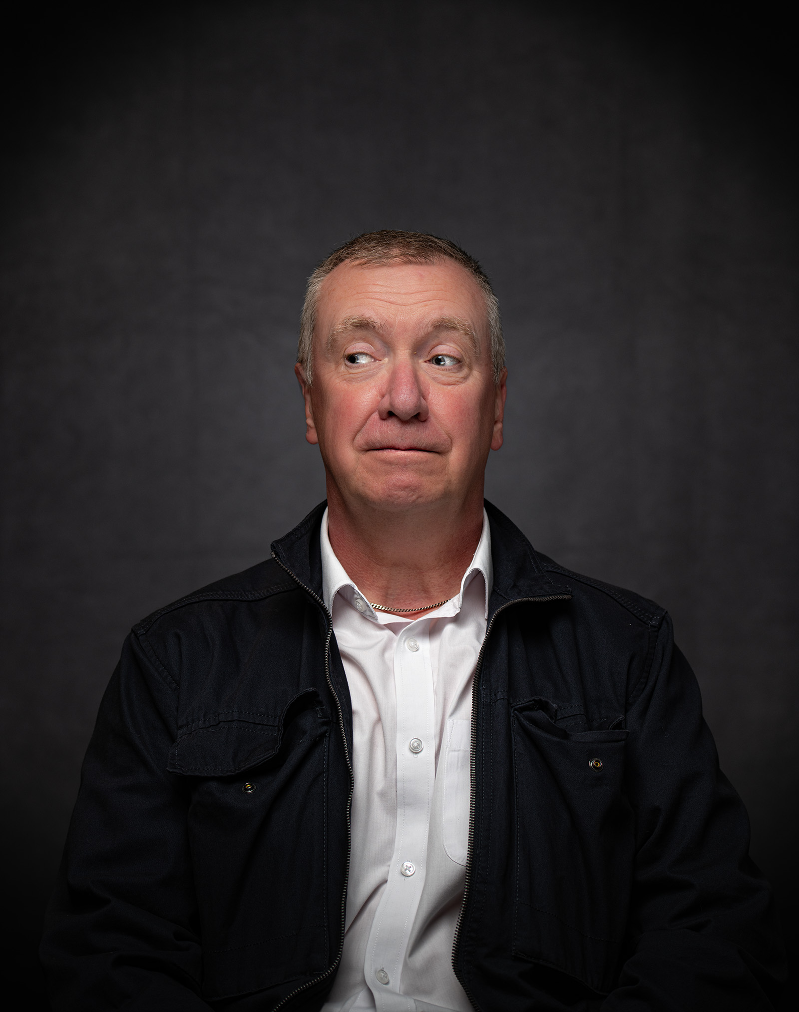 Corporate portrait of a man against a dark grey background