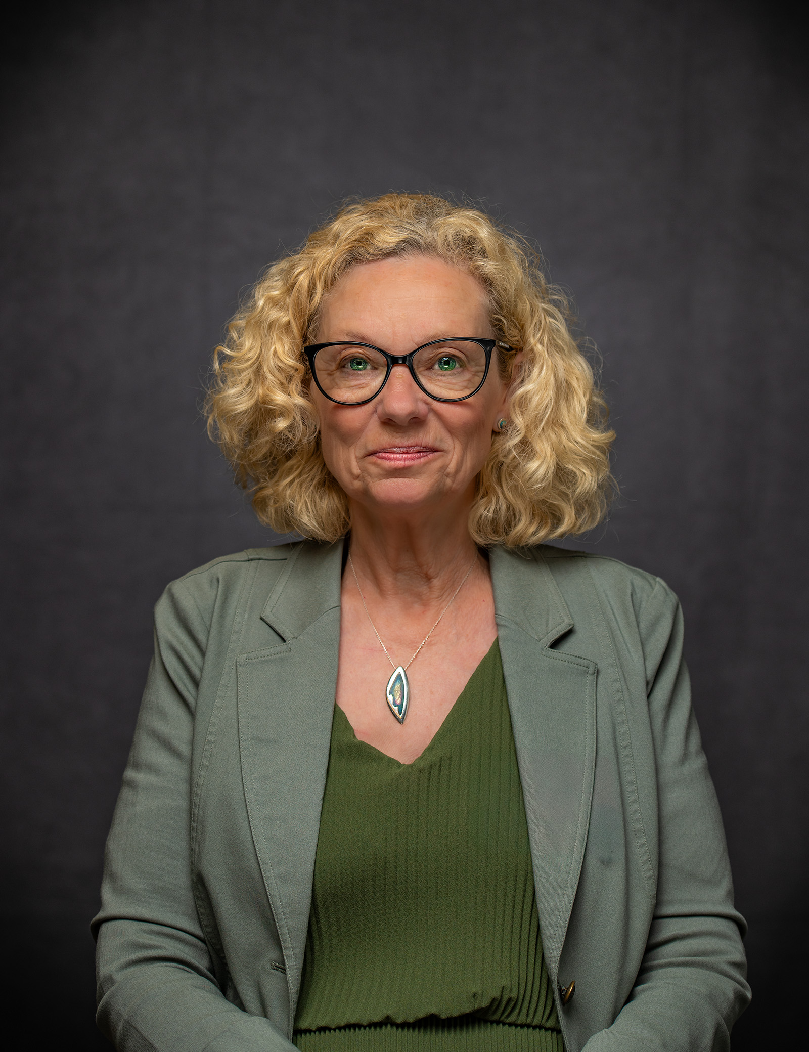 Professional portrait of a woman wearing glasses and a jacket