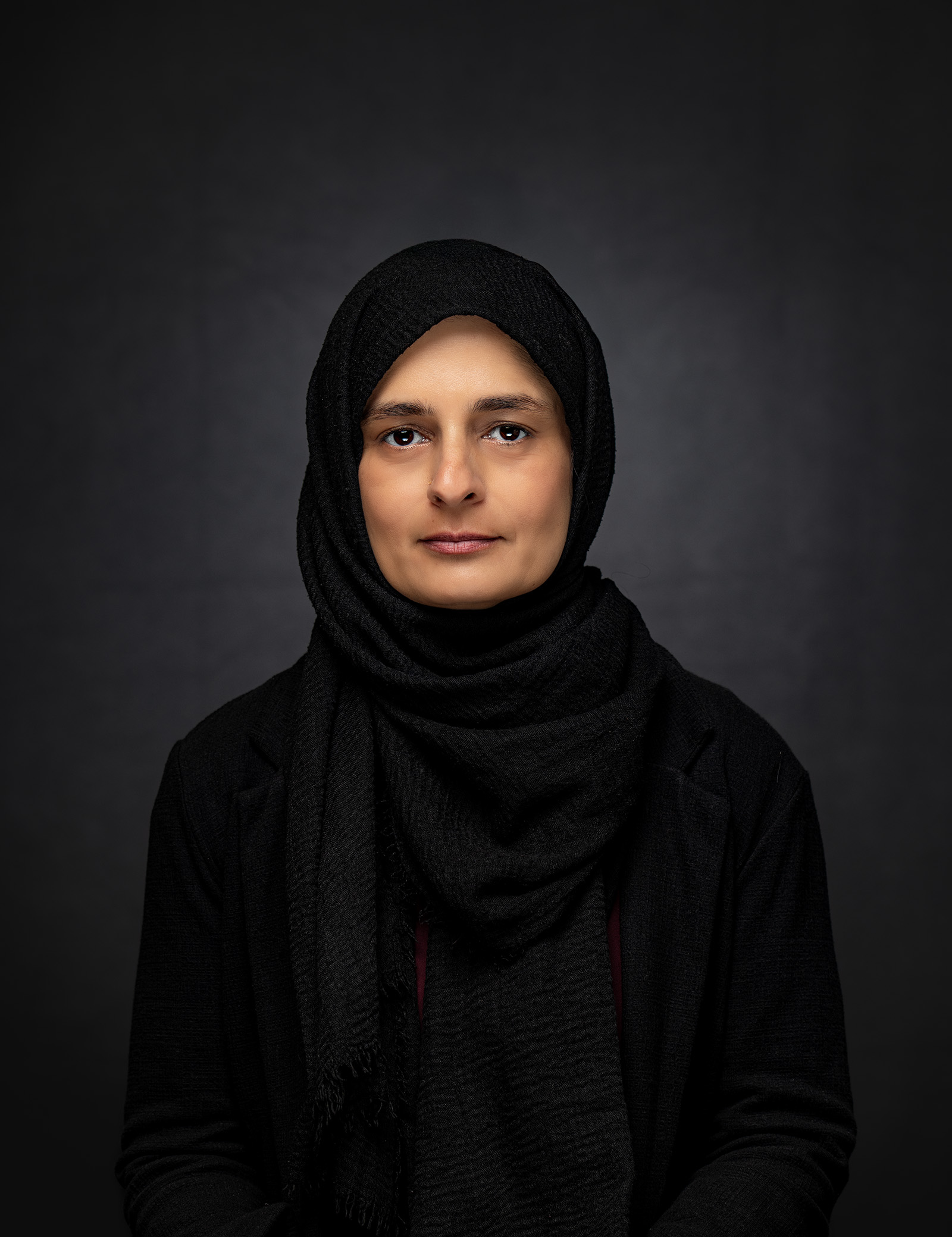 Professional headshot of a woman wearing a black headscarf