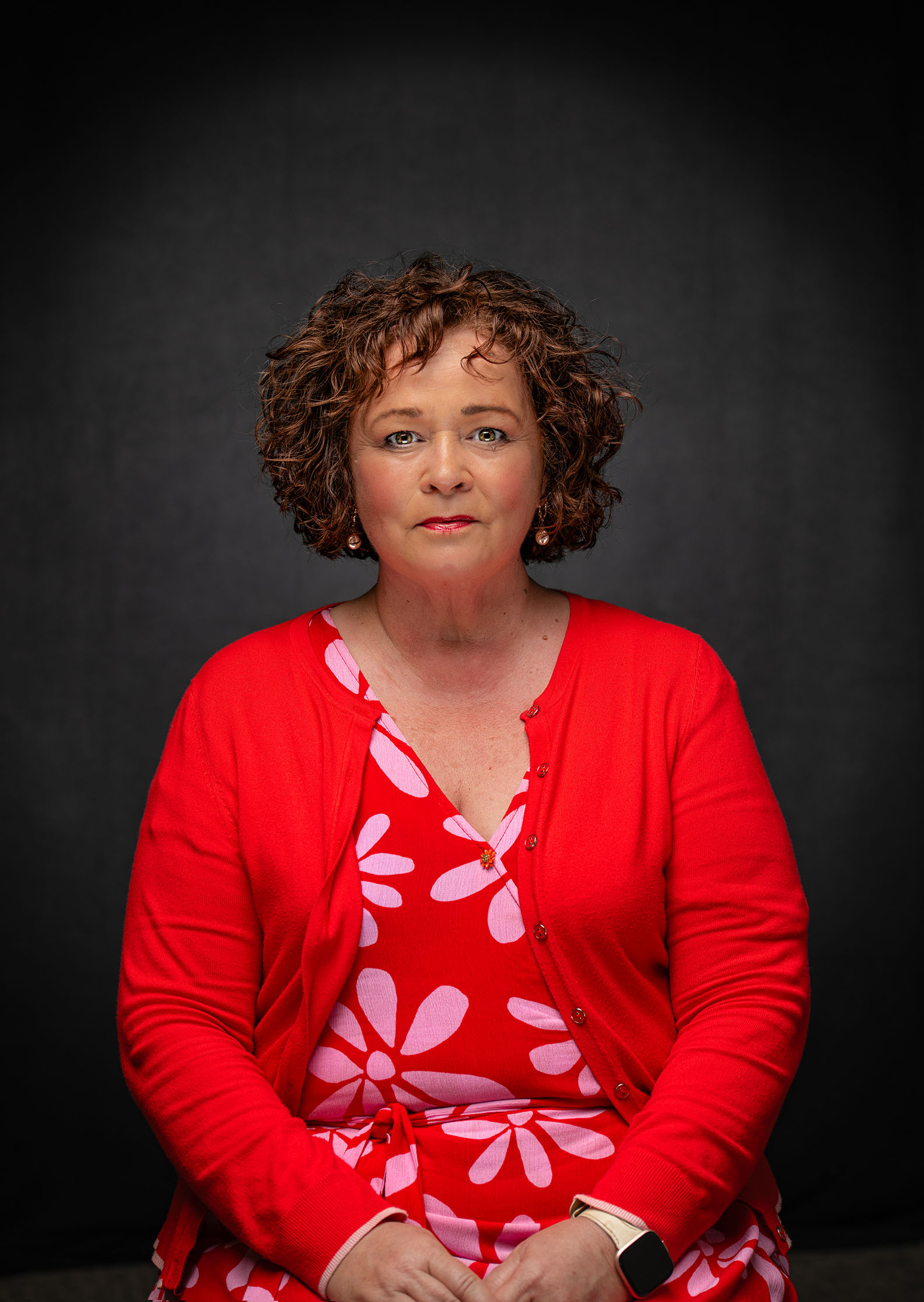 Seated professional portrait of a woman wearing red