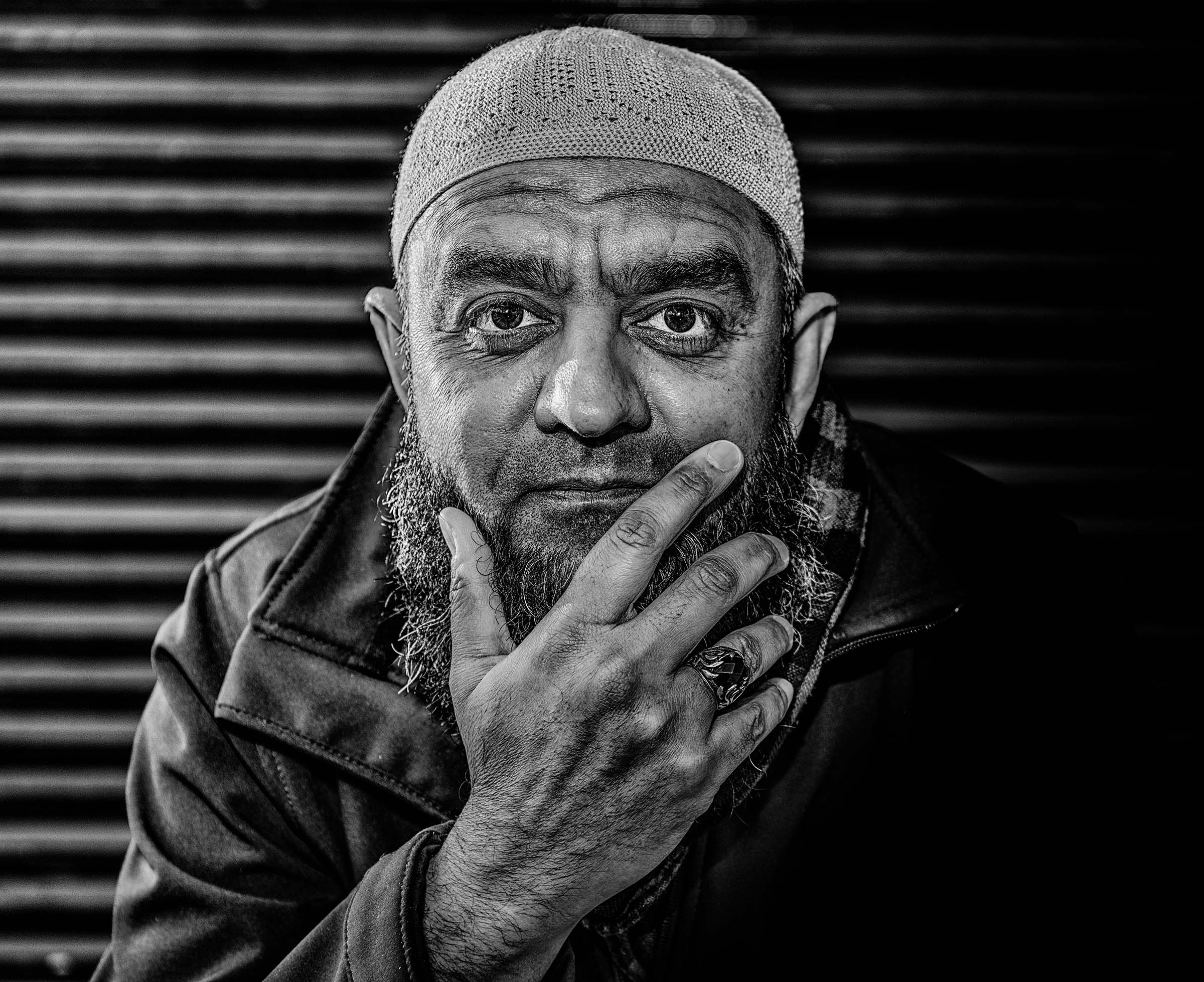 Expressive black-and-white portrait of a man wearing a cap