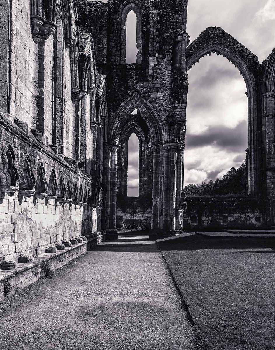 Stone arches framing an abbey courtyard