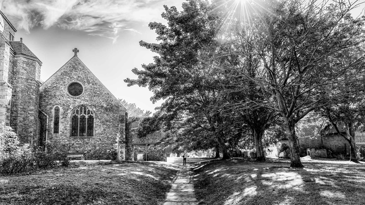 Historic abbey exterior beneath a burst of sunlight