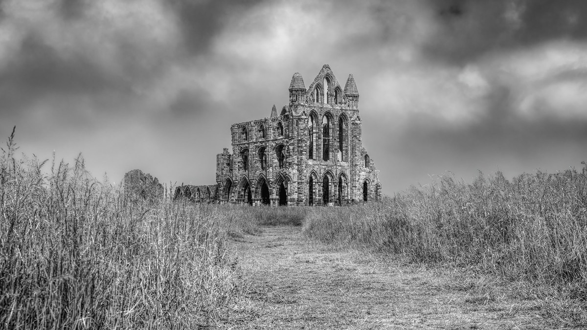 Rough path leading towards a ruined abbey