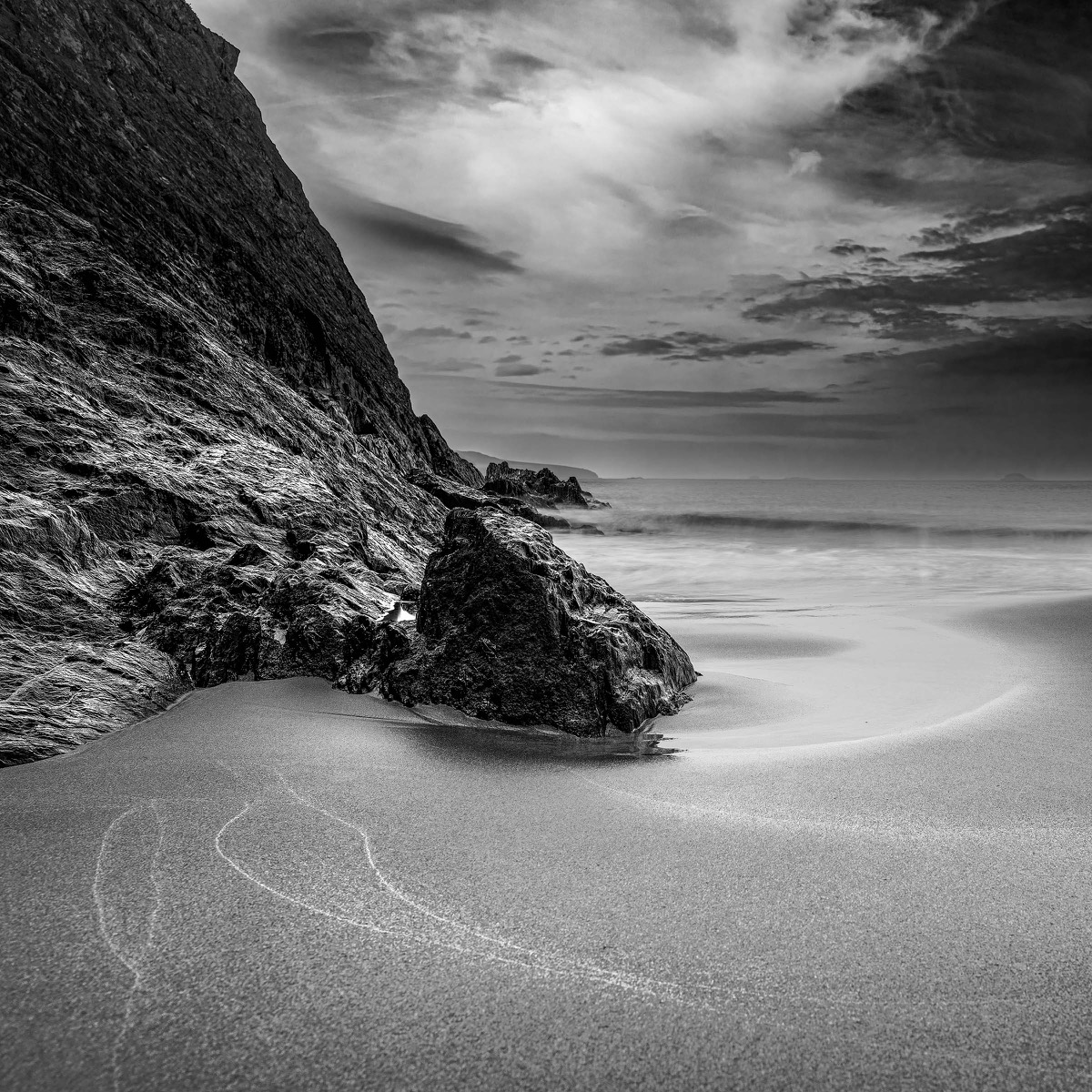 Rock and sweeping water line on a beach