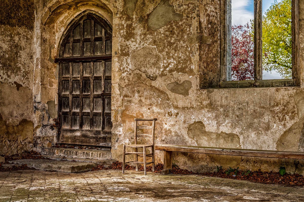 Old church door, wooden chair and a small window